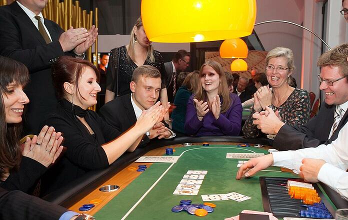 Participants applaud at the poker table during team building.